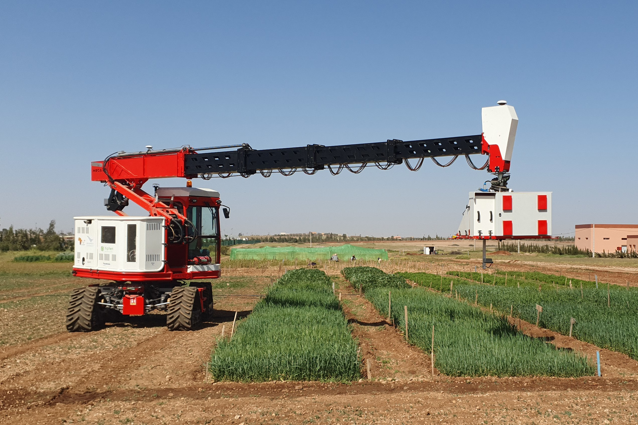 Véhicule autonome à chenilles avecun bras hydraulique adapté aux cultures hautes comme le maïs